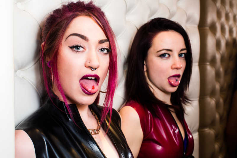 两个时尚的年轻女子展示舌尖穿孔