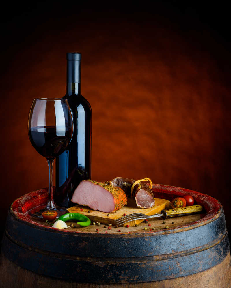 瓶中和杯中的红酒搭配新鲜的熏肉