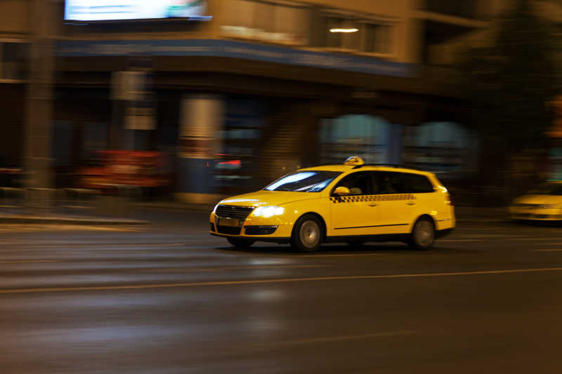 黄色出租车在夜市街道上行驶