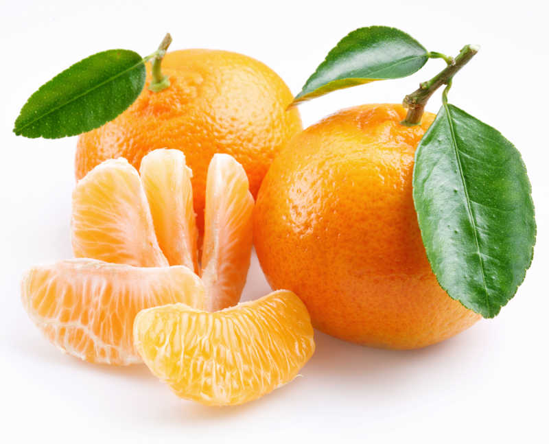 白色背景上的新鲜带叶柑橘