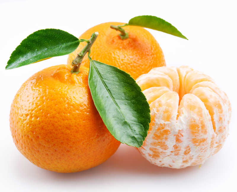 白色背景上的带叶新鲜橘子