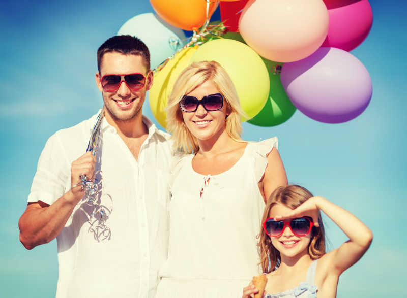 幸福度假中的快乐家庭手拿五颜六色的气球