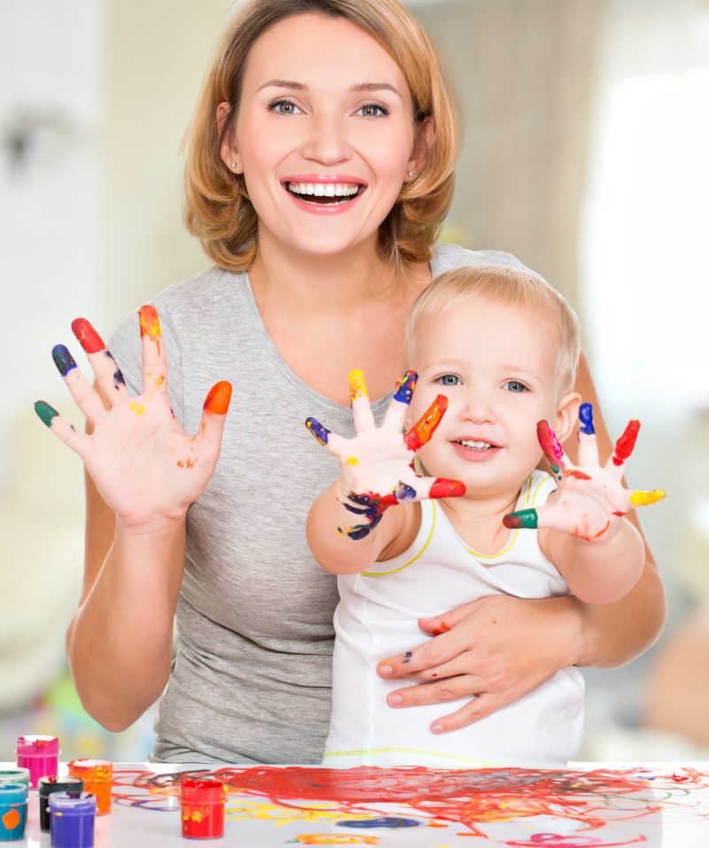 手上涂满颜色的母亲与孩子