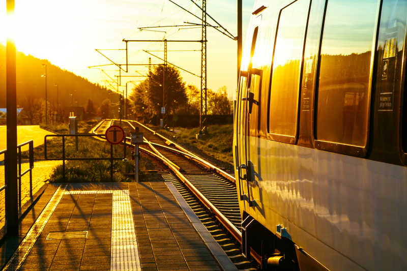 日落时现代旅客列车站在乡村平台