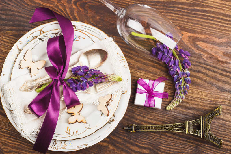 木制背景的紫羽扇豆与银器和装饰品餐具