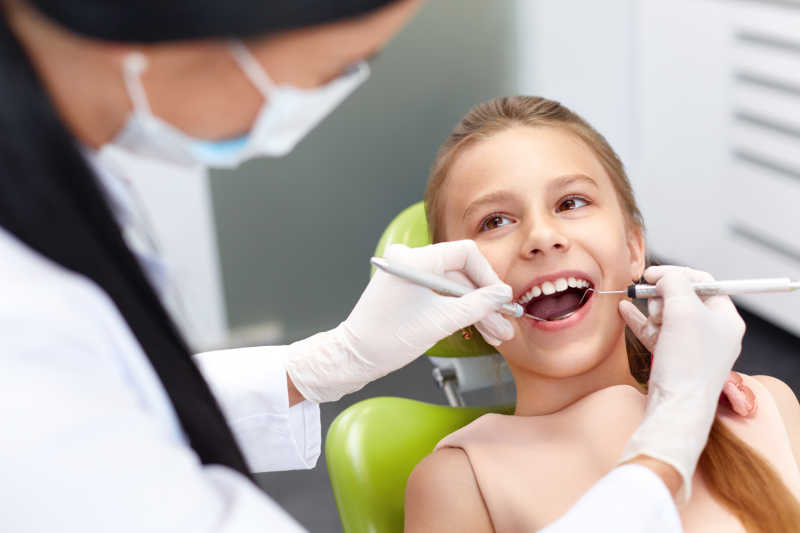 牙医给小女孩检查牙齿