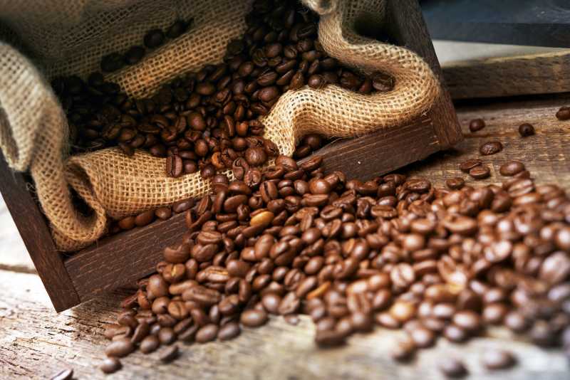 木板上亚麻布袋里的咖啡豆