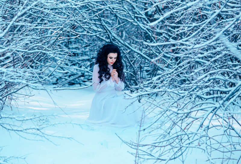 雪地中美丽的冰雪女王装扮的女人