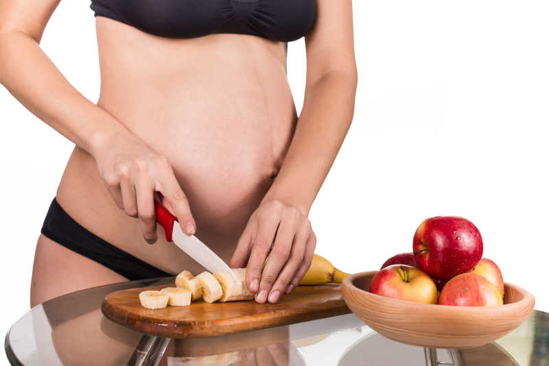 吃健康水果的年轻孕妇