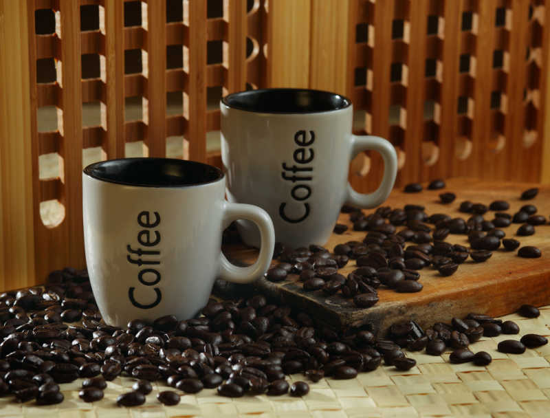 咖啡豆和两个白色的咖啡杯