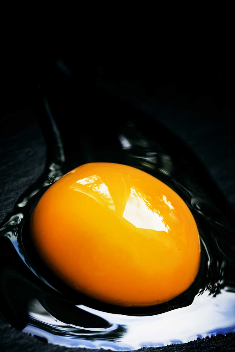黑色背景上蛋液中的蛋黄