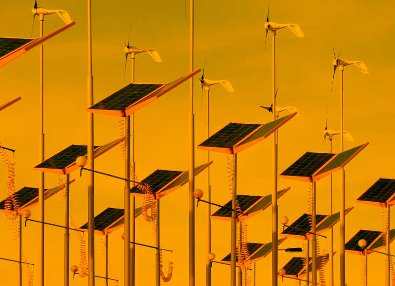 橙色天空下的风力发电机和太阳能电池板