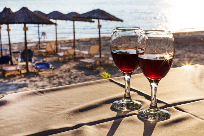 沙滩背景下的两杯红酒