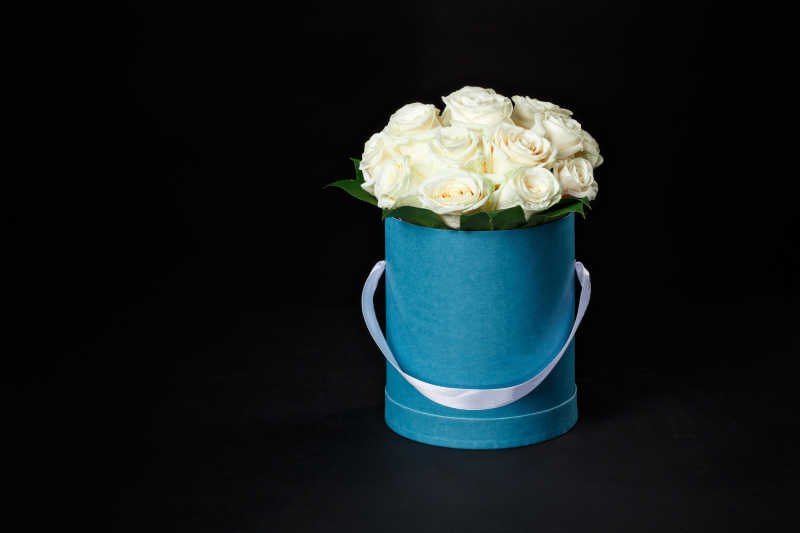 蓝色木桶里的白玫瑰花束