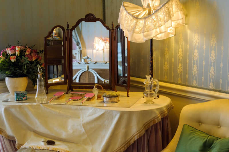 白色化妆台上的中式风格化妆镜和粉色梳子