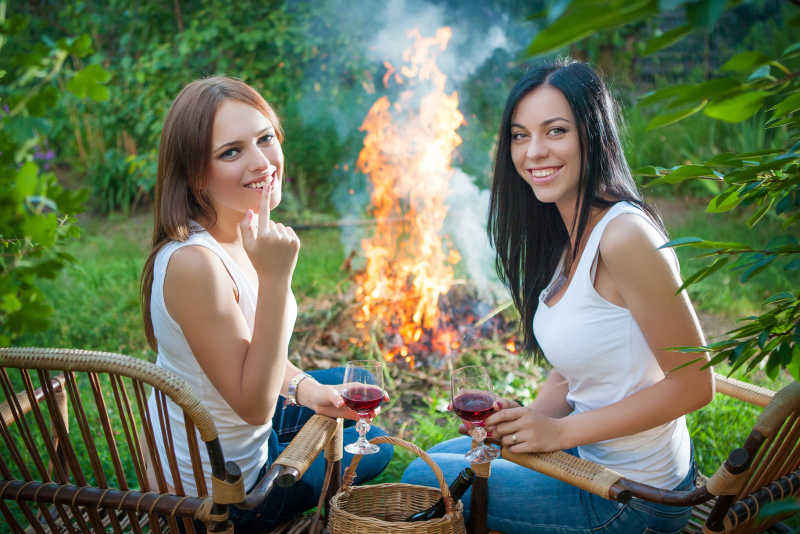 篝火旁喝酒的两个露营美女