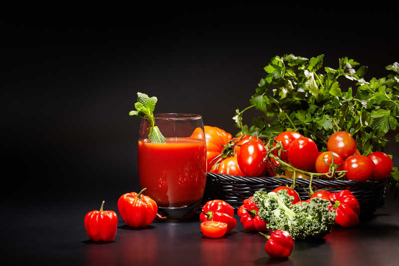 黑色背景中的红色蔬菜和蔬菜汁