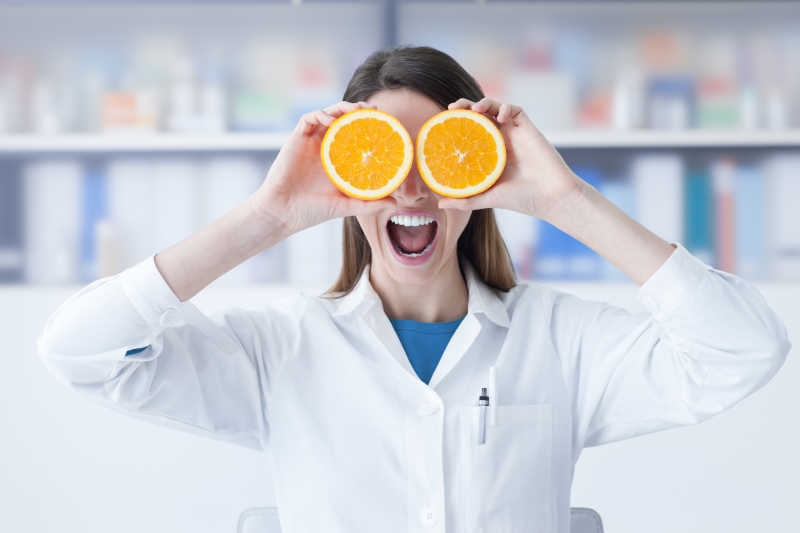 营养学家拿着橙子放在眼睛上