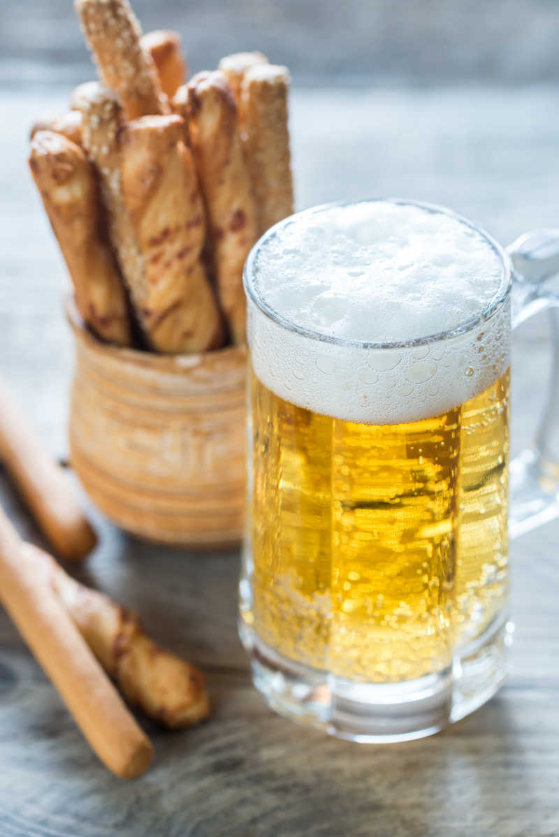 桌子上的啤酒和面包棒
