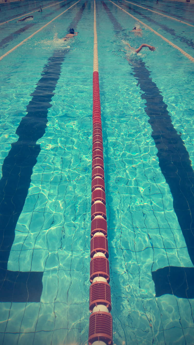 正在蓝色游泳池里游泳的两名运动员
