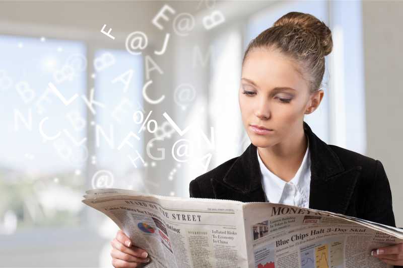 年轻女子在阅读报纸