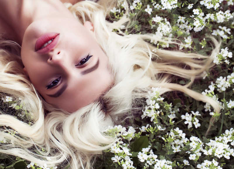 躺在开满鲜花的草地上休息的女孩