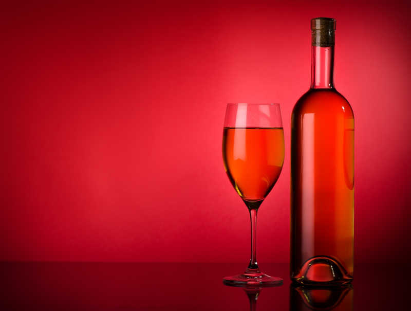 红色背景图的葡萄酒和酒杯