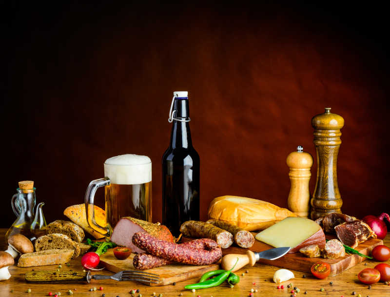 褐色背景下木桌上的啤酒和熏肉食物