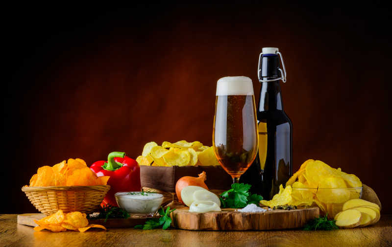 褐色背景下木桌上的啤酒和各种食材