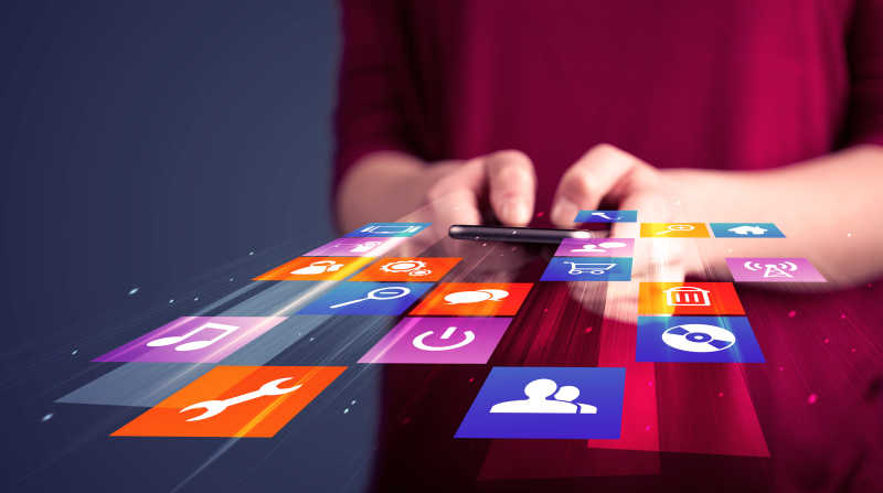 红衣服的女人手里的智能手机中的彩色应用图标