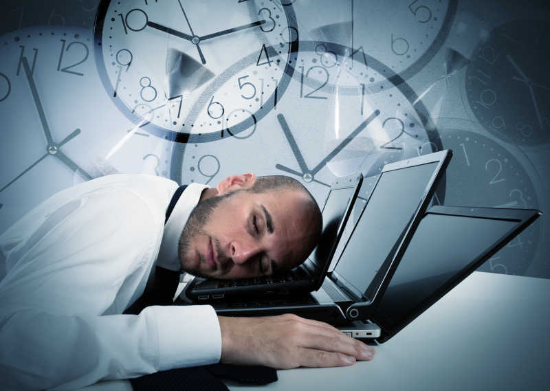 背景手表上的商人睡在笔记本电脑