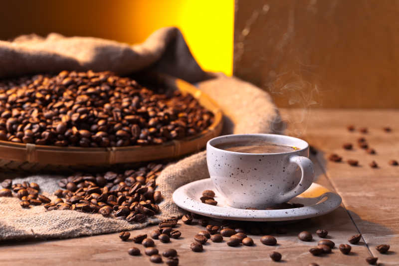 早晨的阳光照射下美味的新鲜的咖啡早餐和棕色的咖啡豆