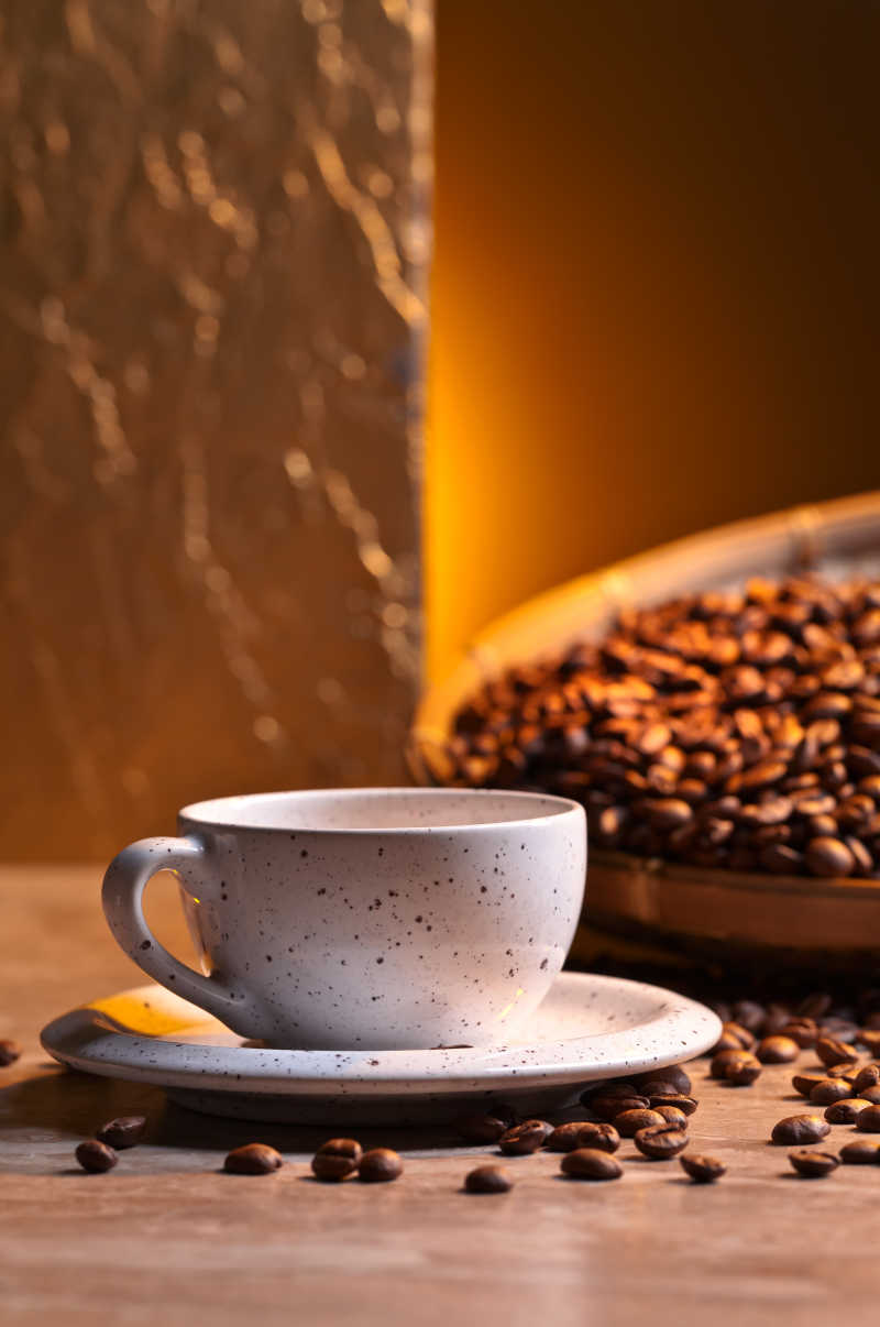 放在木桌上的一杯咖啡和棕色的咖啡豆