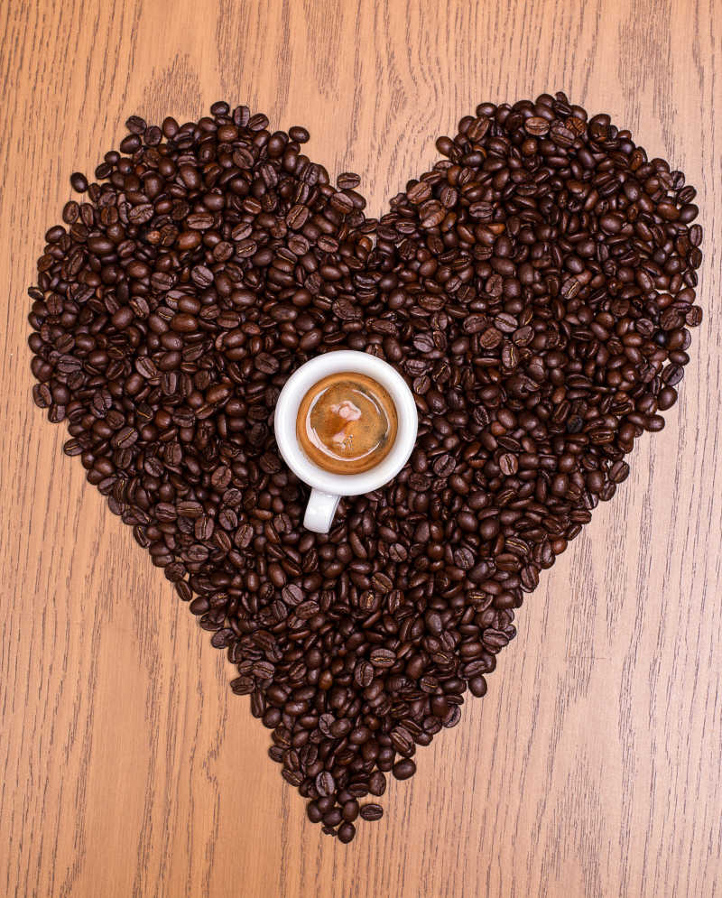 摆成心形形状的咖啡豆和咖啡