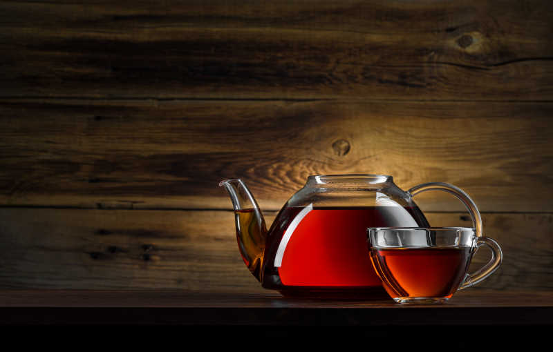 木制背景下的红茶玻璃茶壶