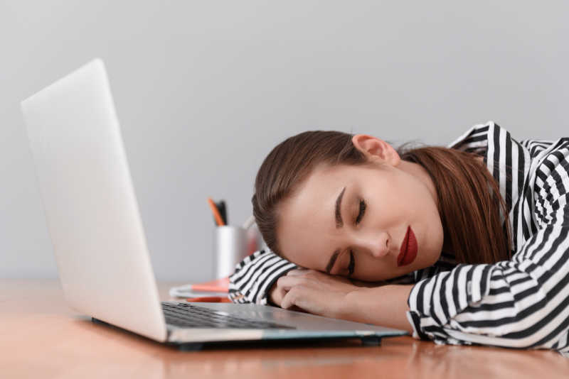 筋疲力尽的女人在上班时小睡片刻