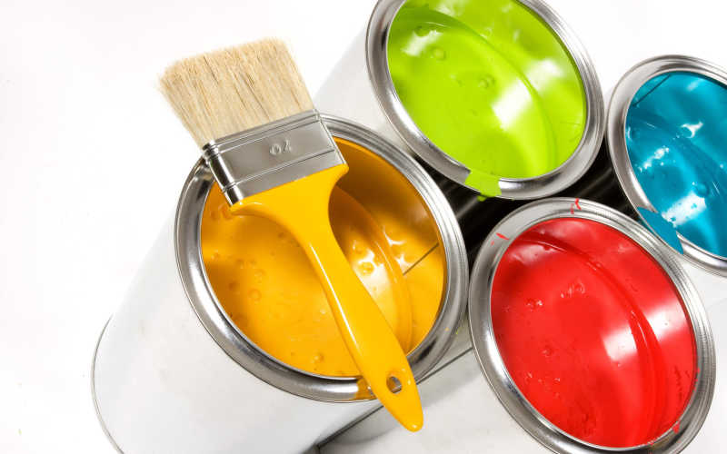 不同颜色的油漆桶和黄色油漆刷