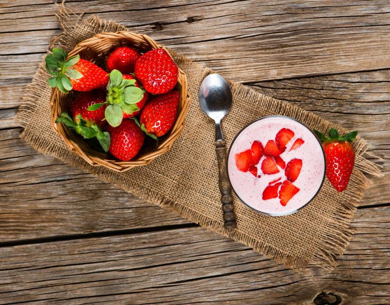 木桌上的草莓奶昔和新鲜的草莓