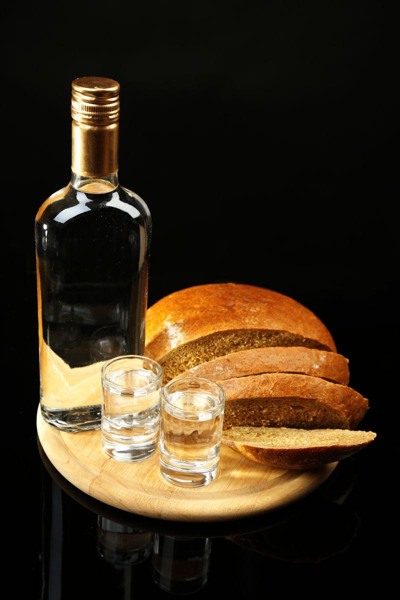 一瓶伏特加和新鲜的面包在木板上