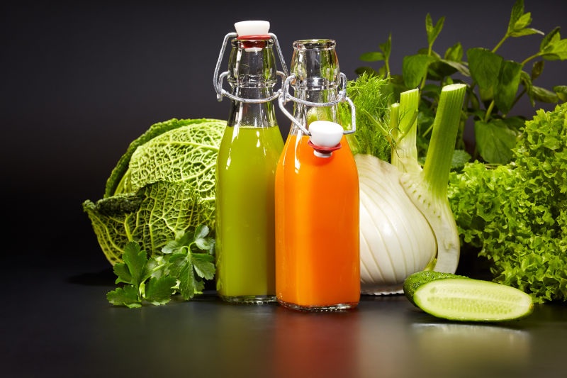 新鲜的蔬菜汁和绿色蔬菜在桌子上
