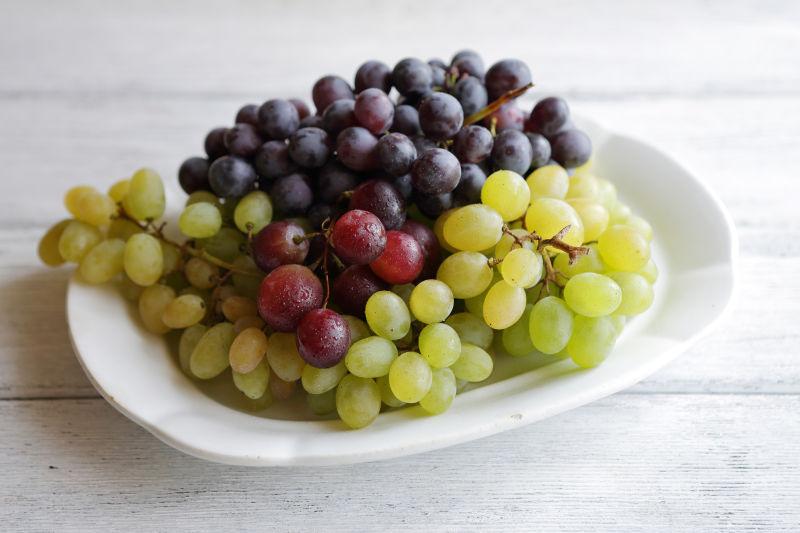 盘子里的白葡萄和紫葡萄