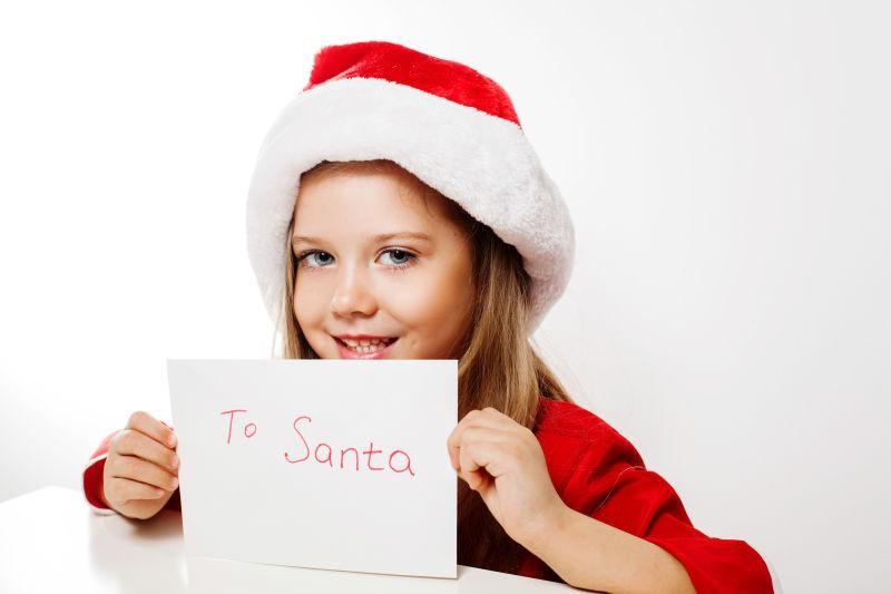戴着圣诞帽的小女孩拿着一张信封