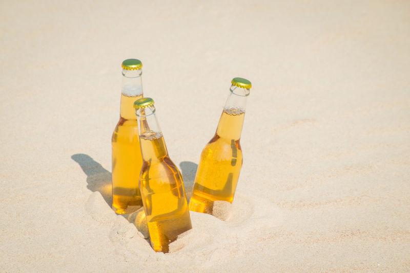 黄色沙滩上的三瓶啤酒