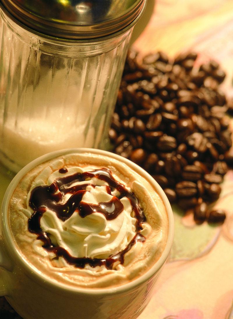 桌子上的花样奶油咖啡和咖啡豆