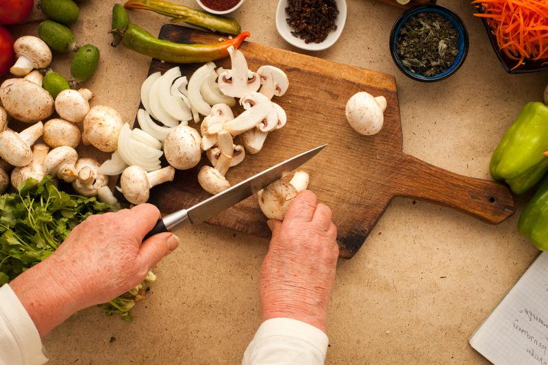 女人用刀切碎蘑菇做健康素食
