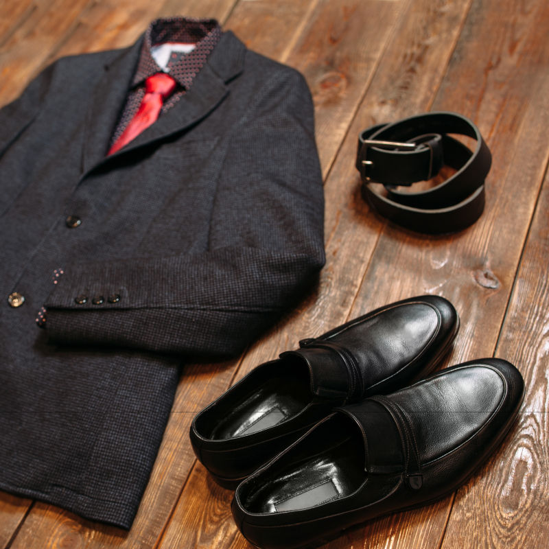 木板上的男士西装领带衬衫皮鞋和皮带