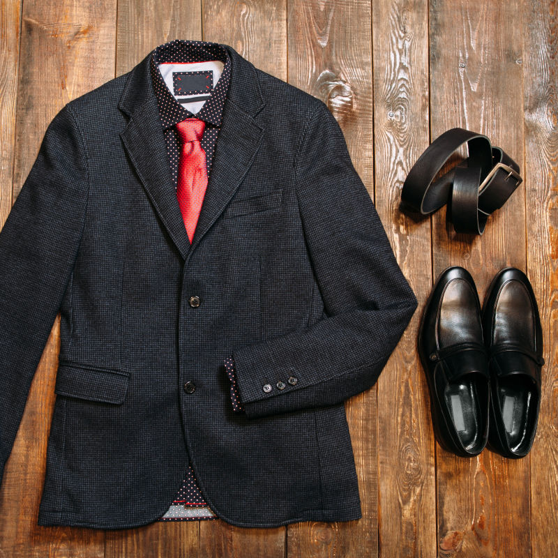 木板上的男士衬衫西装红色领带鞋子和皮带