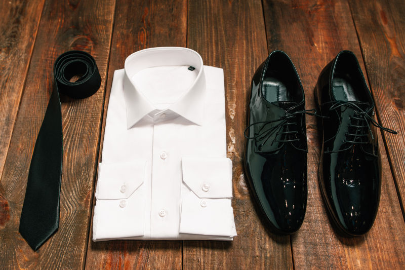木板上的男士黑领带皮鞋和白衬衫