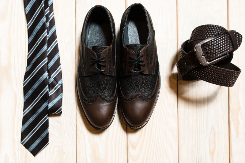 木制地板上的男士领带皮鞋和皮带