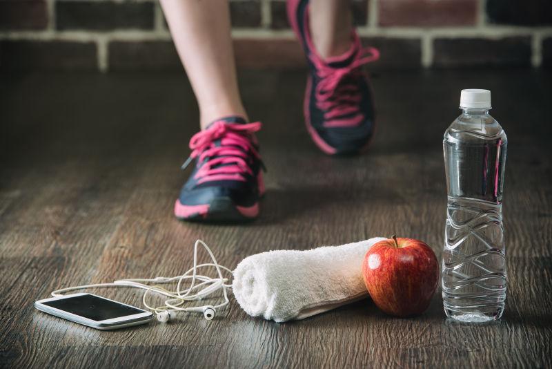健身跑步的年轻人的手机毛巾水和苹果